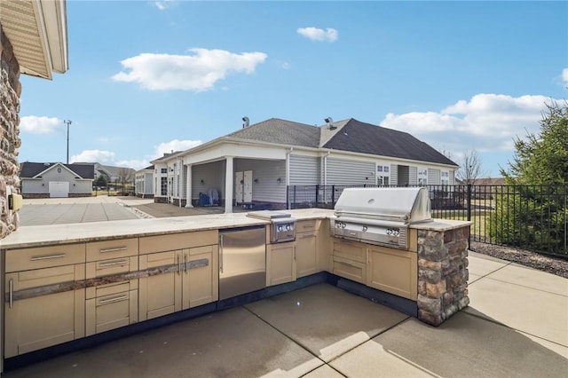 view of patio featuring an outdoor kitchen, fence, and grilling area