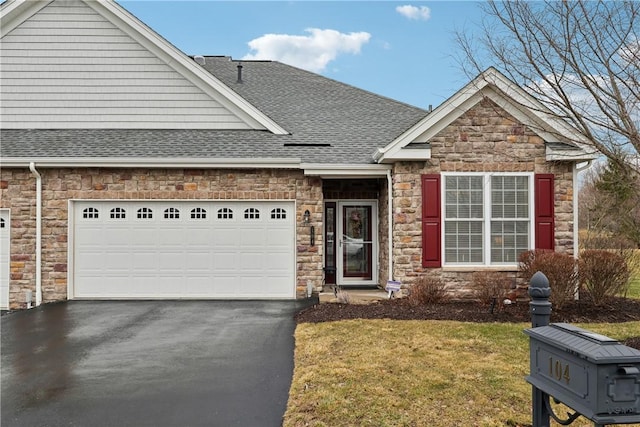 view of front of home featuring a front yard, an attached garage, driveway, and roof with shingles