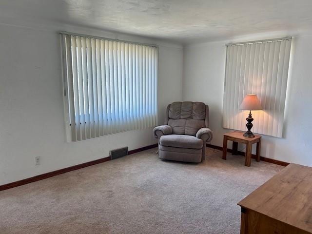 sitting room with carpet flooring, visible vents, and baseboards