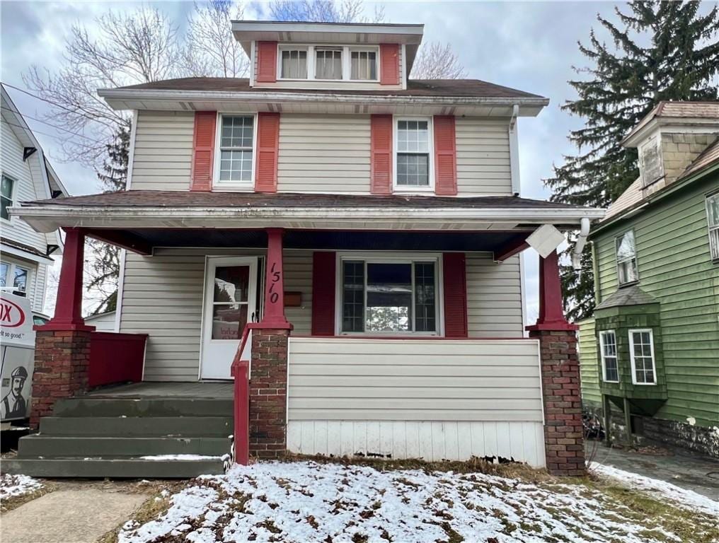 american foursquare style home with covered porch