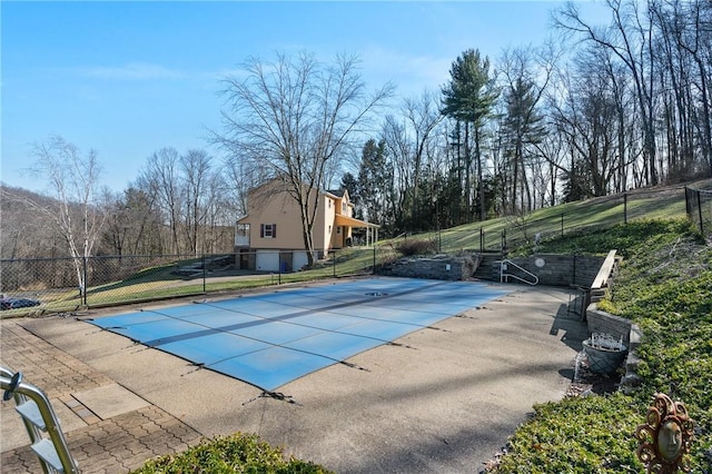 community pool with a patio area and fence