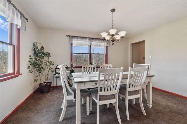 carpeted dining room with baseboards and a notable chandelier