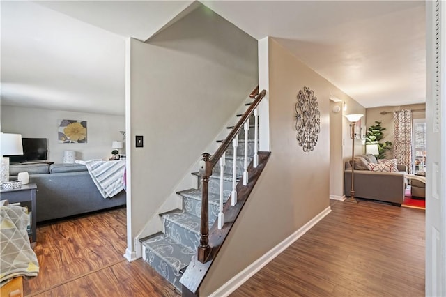 stairs with wood finished floors and baseboards
