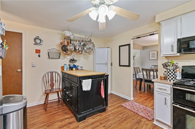kitchen with light wood-style flooring, white cabinetry, ceiling fan, light countertops, and black appliances