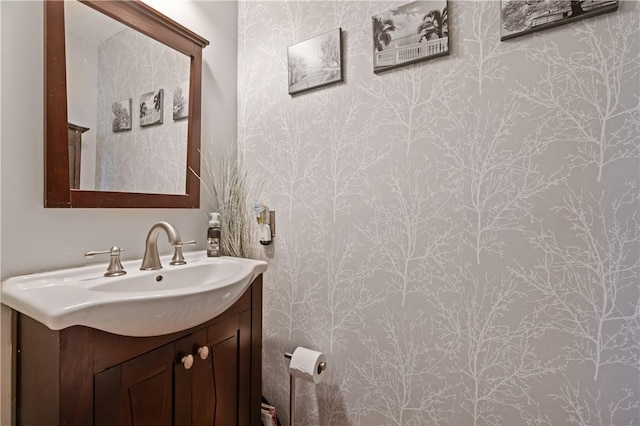 bathroom with vanity and wallpapered walls