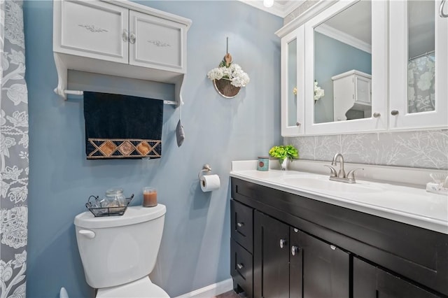 bathroom with baseboards, vanity, ornamental molding, and toilet