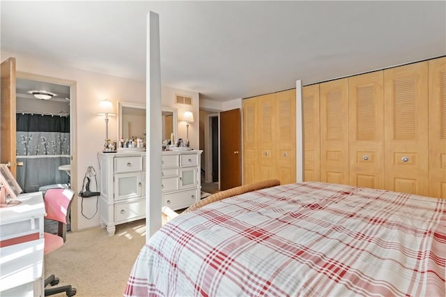 carpeted bedroom featuring visible vents and multiple closets