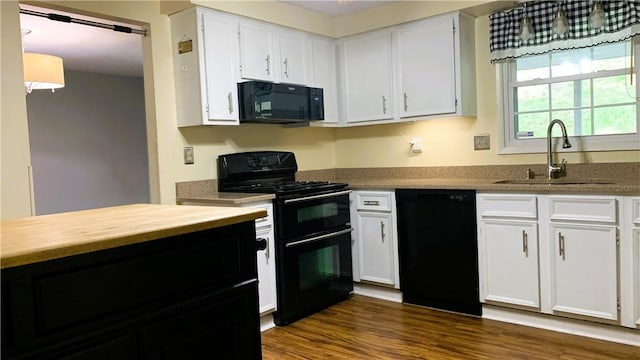 kitchen with black appliances, dark wood-style flooring, a sink, and white cabinets