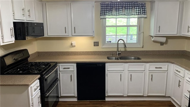 kitchen featuring white cabinets, light countertops, a sink, and black appliances