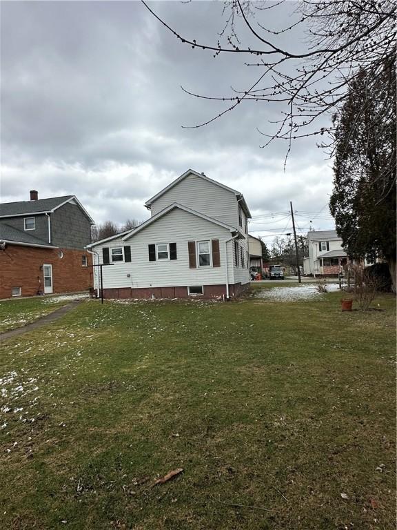 rear view of house featuring a yard