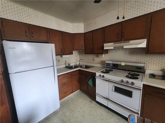 kitchen featuring under cabinet range hood, white appliances, light countertops, and a sink