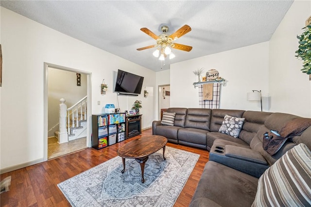 living room with ceiling fan, stairway, a textured ceiling, and wood finished floors