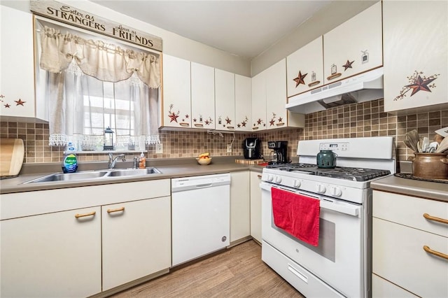 kitchen with white appliances, white cabinets, under cabinet range hood, and a sink