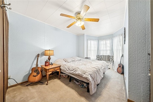 carpeted bedroom featuring crown molding and a ceiling fan