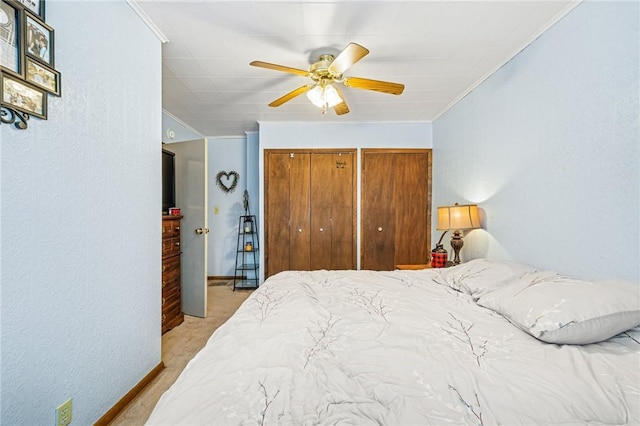 bedroom with baseboards, light carpet, a ceiling fan, and crown molding