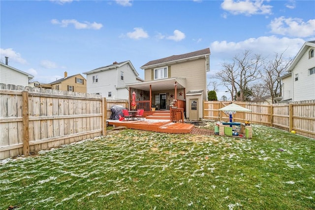 back of house with a deck, a yard, and a fenced backyard