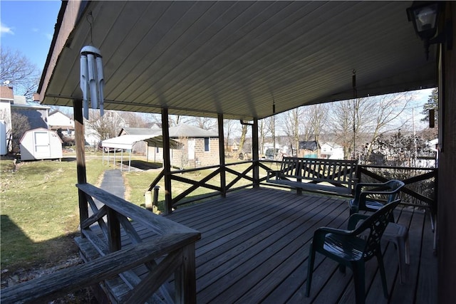 deck featuring a lawn, a storage unit, and an outdoor structure