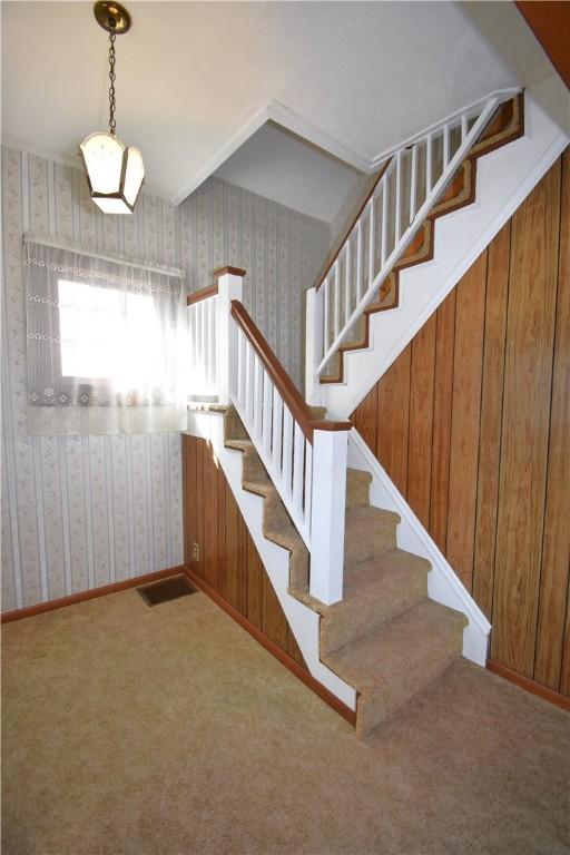 staircase with visible vents, baseboards, carpet, and wallpapered walls