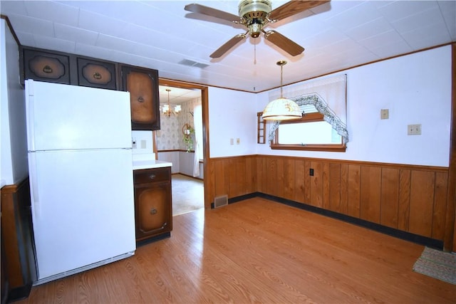 kitchen with light wood-style flooring, visible vents, wainscoting, and freestanding refrigerator