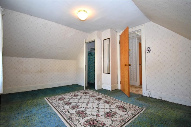 additional living space with baseboards, lofted ceiling, carpet floors, and wallpapered walls