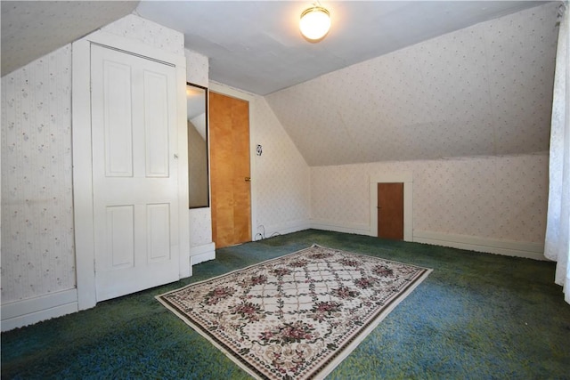 additional living space with wallpapered walls, lofted ceiling, and carpet floors