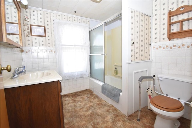 bathroom with wallpapered walls, tile walls, toilet, and vanity