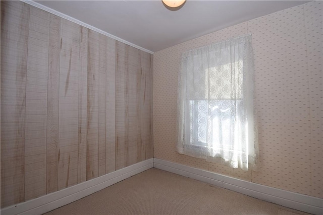 spare room with wallpapered walls, crown molding, baseboards, and carpet floors