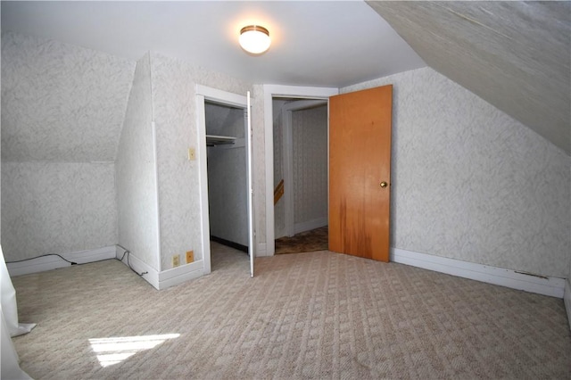 additional living space with carpet floors and vaulted ceiling