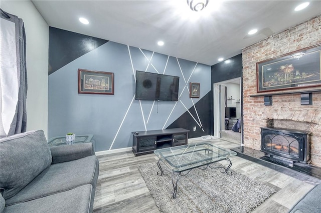 living area featuring recessed lighting, a fireplace, baseboards, and wood finished floors