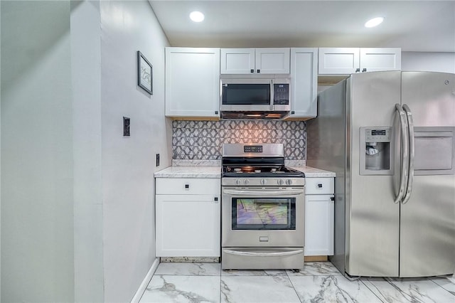 kitchen with light countertops, tasteful backsplash, marble finish floor, and stainless steel appliances