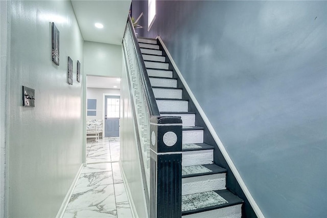 stairway featuring baseboards and marble finish floor