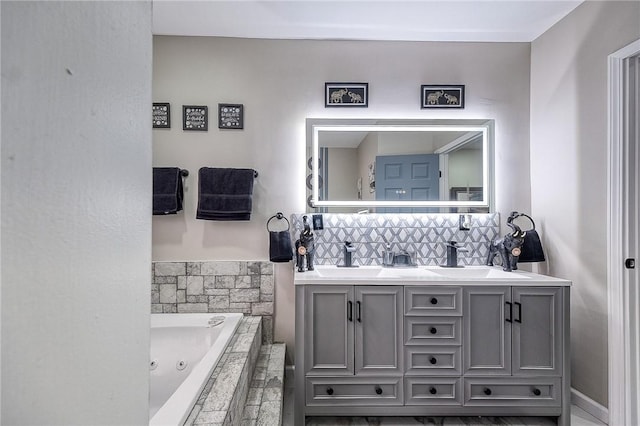 bathroom featuring double vanity, a jetted tub, tasteful backsplash, and a sink