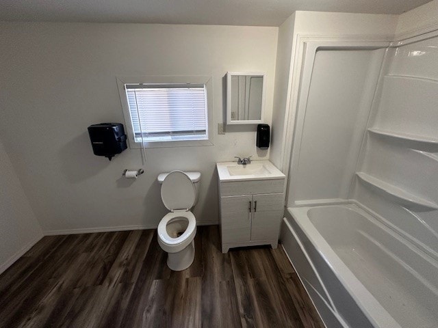 bathroom with vanity, wood finished floors, baseboards, tub / shower combination, and toilet