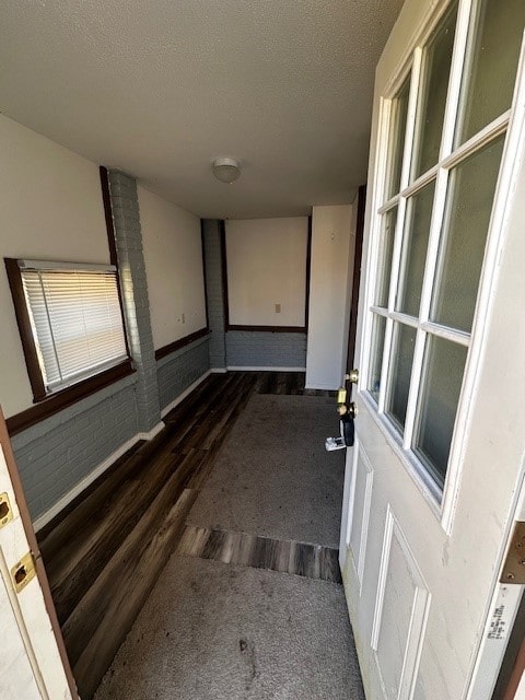 hallway featuring wood finished floors and a textured ceiling