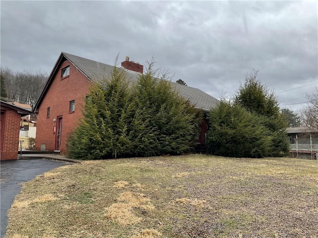 view of home's exterior with brick siding and a chimney