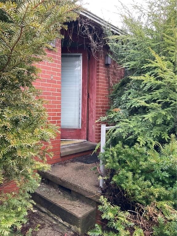 entrance to property featuring brick siding