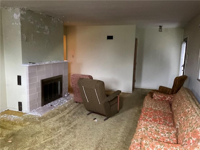 living room with a tiled fireplace and carpet floors