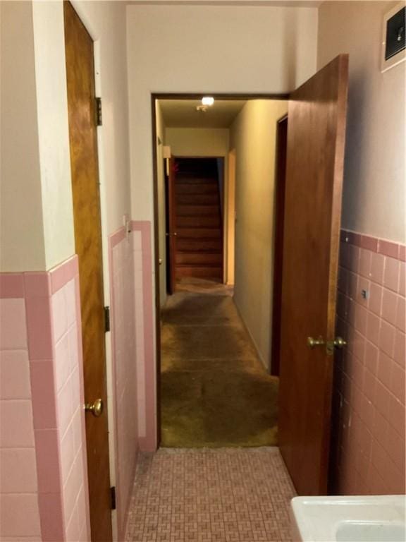 hallway with a wainscoted wall and tile walls