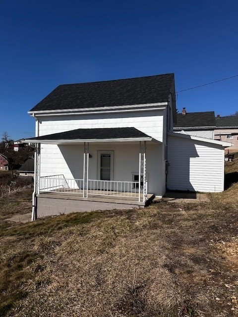 view of front of house featuring covered porch and a shingled roof