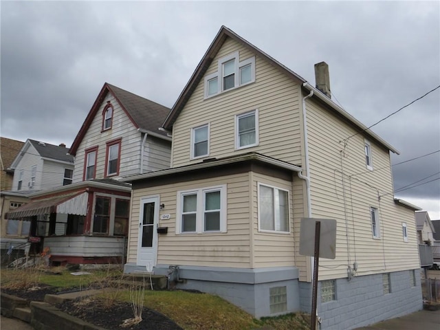 rear view of house with a chimney and entry steps