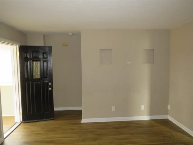 foyer entrance with baseboards and wood finished floors