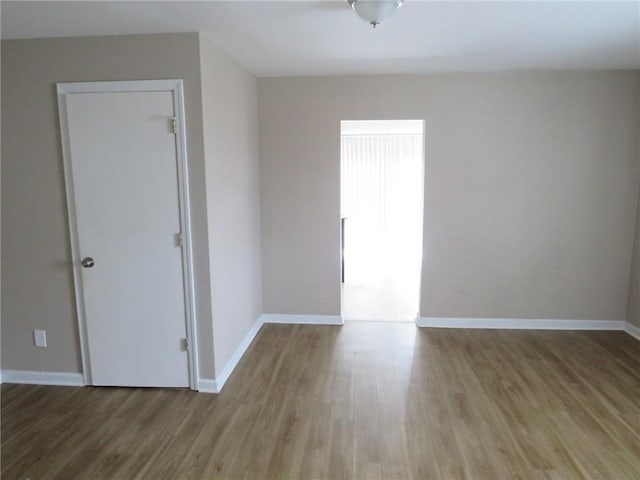 empty room featuring baseboards and wood finished floors