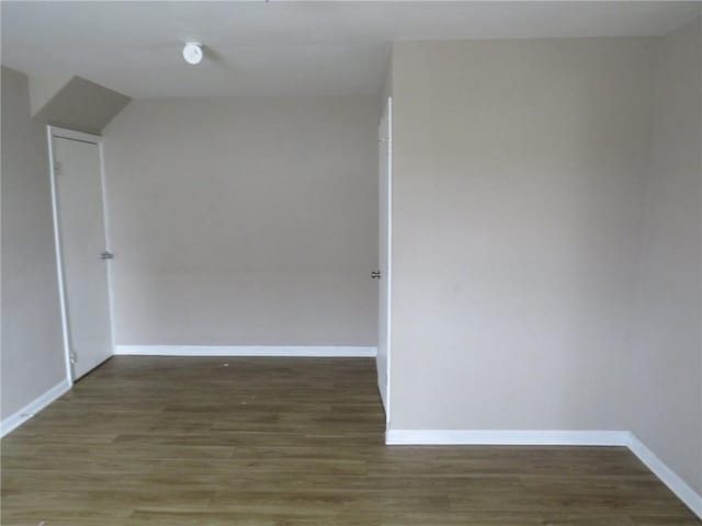 spare room featuring baseboards and wood finished floors