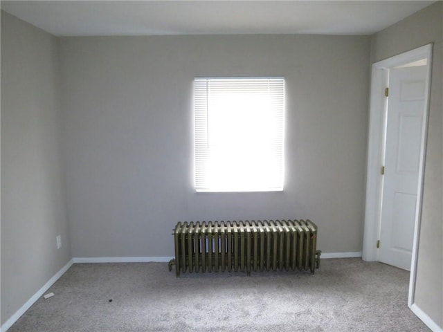 unfurnished room featuring carpet flooring, radiator heating unit, and baseboards