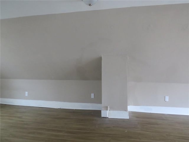 additional living space featuring baseboards, lofted ceiling, and wood finished floors