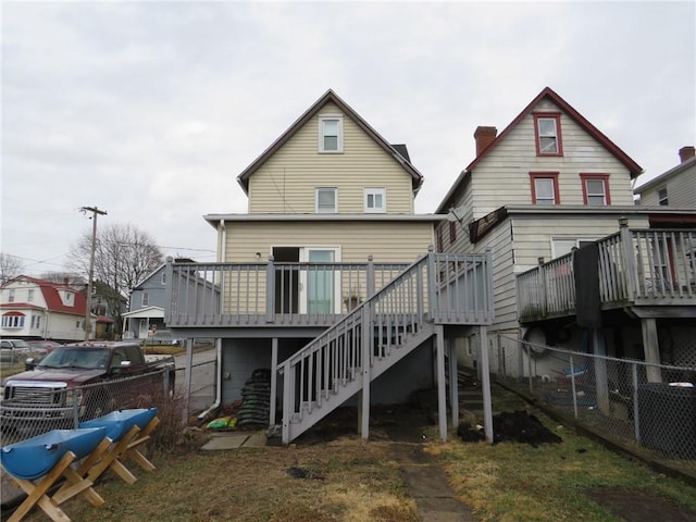 back of property with stairs, a deck, and fence