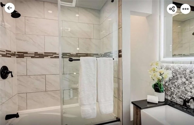 full bathroom with decorative backsplash, a tile shower, and a sink