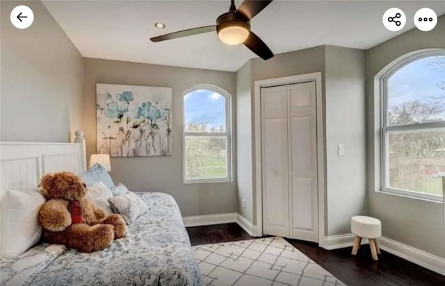 bedroom with a closet, baseboards, and dark wood-style flooring