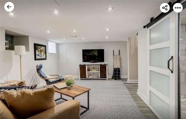 living area featuring recessed lighting, baseboards, a barn door, and dark wood-style flooring