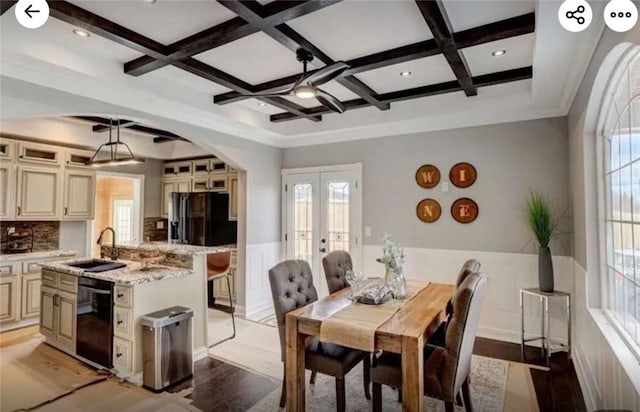 dining area featuring french doors, light wood-style floors, coffered ceiling, and wainscoting